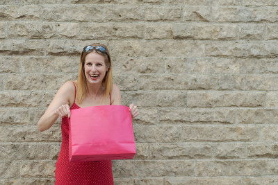 Young blond woman in red dress is happily laughing