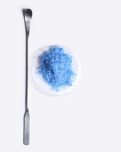 化学手表玻璃中的硫酸铜(II)放置在实验台上的搅拌棒旁边。