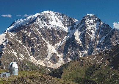 在高加索山脉的天文台。以雪山为背景的天文台。在阳光明媚的夏日，美丽的山景
