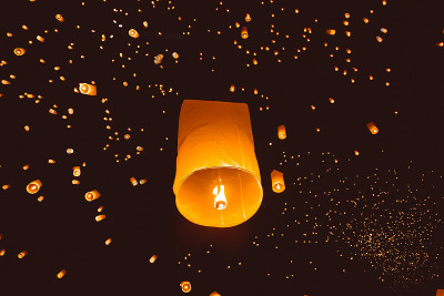 在泰国新年晚会上，人们在夜空中放飞灯笼