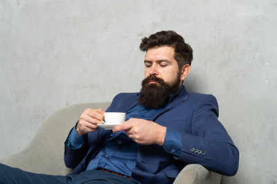 再来一杯轻松的茶。男经理坐在扶手椅上喝咖啡放松。工作休息