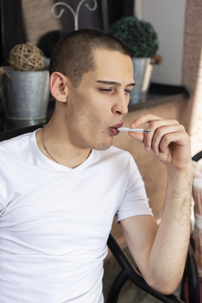 年轻男子点燃香烟的肖像
