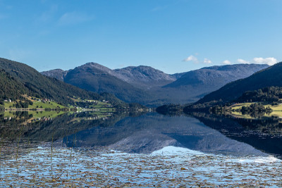 挪威山湖映在阳光明媚的日子里的风景
