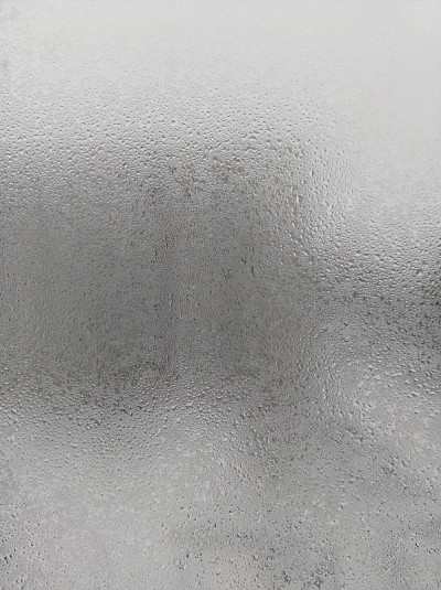 水滴凝结在雾蒙蒙的玻璃窗上