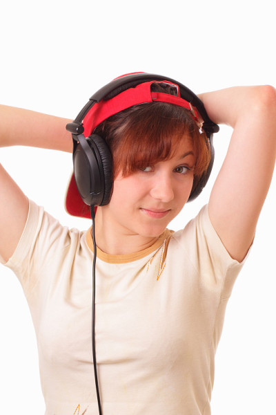 迷人的年轻女孩戴着耳机听音乐
