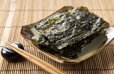用木桌上的盘子盛着韩国海带。