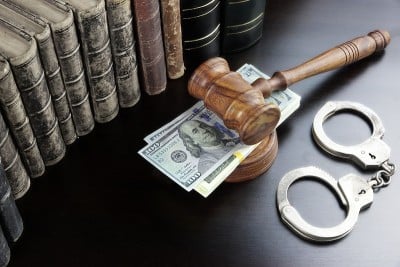 法官的木槌，手铐，现金和书在黑色的桌子上