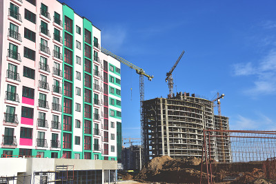 塔吊在蓝天的背景行动。新建多层建筑