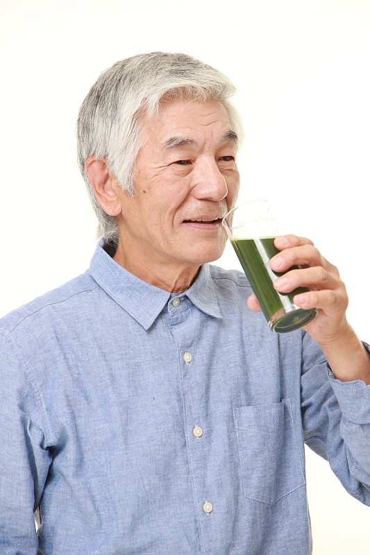 日本老男人和绿色蔬菜汁