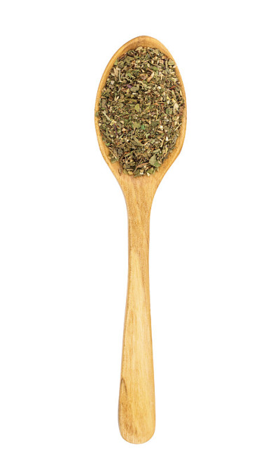 用木勺将普罗旺斯草药混合在白色的背景上。俯视图