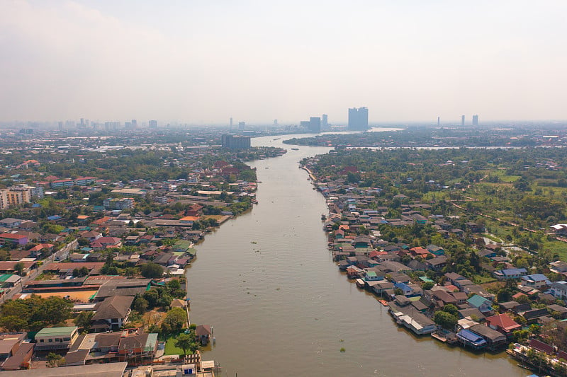 鸟瞰当地住宅与Phasi Charoen，湄南河或运河，自然树木，Nonthaburi市，泰国在亚洲