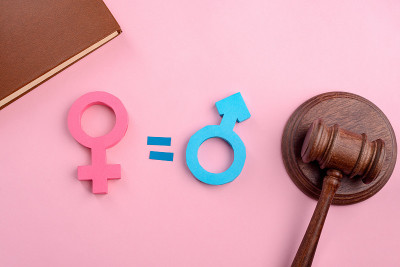 粉色背景上的女性、男性标志和木槌