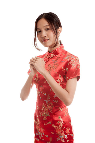 亚洲女孩穿着中国旗袍，做着祝贺的手势