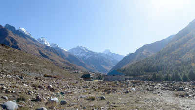 喜马拉雅山上的高山小木屋，为登山者、登山者和徒步旅行者提供庇护。背景中是一个交错重叠的支脉山脊v形山