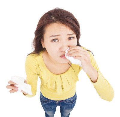 亚洲年轻女子用纸巾流鼻涕