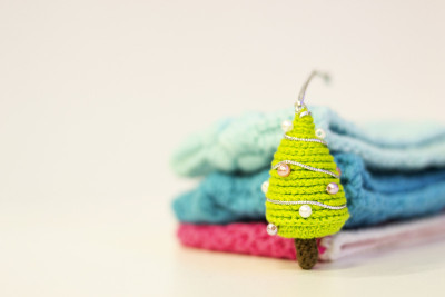 手工编织的圣诞礼物。Amigurumi玩具。近距离的圣诞树编织针在一个模糊的背景。色彩斑斓的线程。本