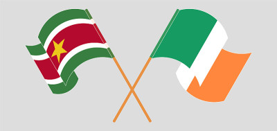 Crossed and waving flags of Suriname and Ireland