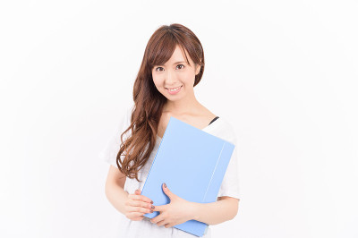 年轻的亚洲女人拿着报告，看着摄像机。