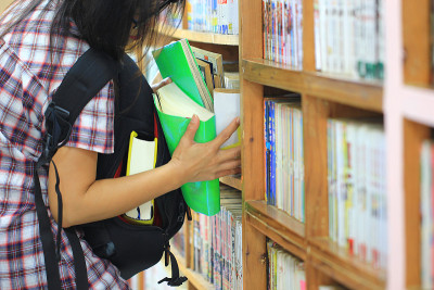 试图偷图书馆书架上的书的女人，(病态偷窃，盗窃癖)