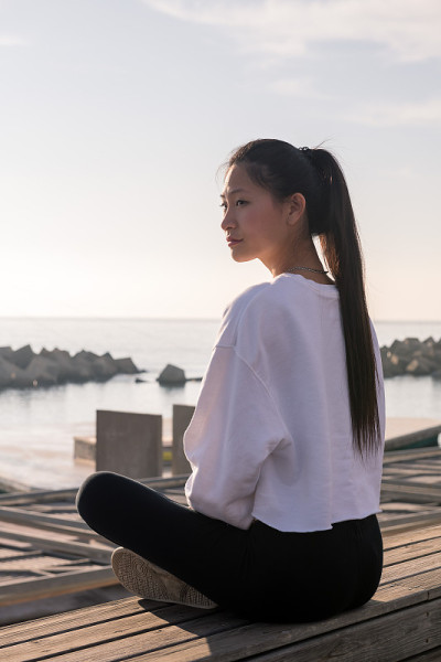 年轻的亚洲女人坐后放松冥想