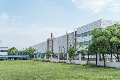 厂房位于市郊，以工业厂房为背景