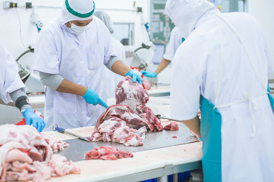在工厂里切肉的工人
