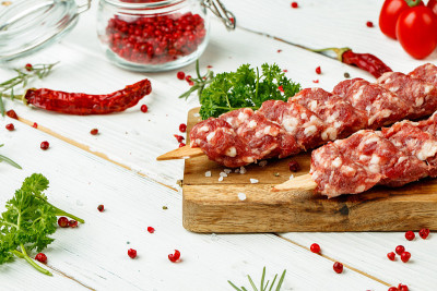 生的卢拉烤肉串与香料串在木板上