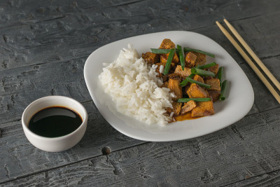 米饭和豆腐在桌子上的白碗里烤着。