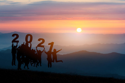 企业团队举手剪影，跳跃到美丽的金色天空，从文字2021背景。企业成功的理念，胜利，实现目标目标，企业