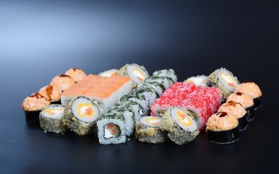 深色的石头背景上是五颜六色的海鲜卷和米饭