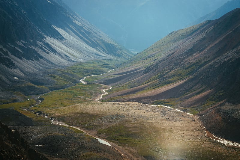 风景优美的高山景观，斑驳的山谷与河流在金色的阳光下。多色河谷，山河红坡，阳光灿烂的高原风光。不寻常的