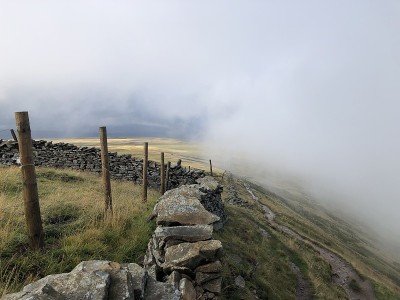 在约克郡的三峰，路径通过云，有力的云对蓝色的天空背景