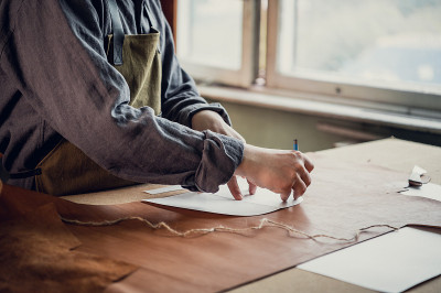 A young apprentice transfers a pattern from paper 
