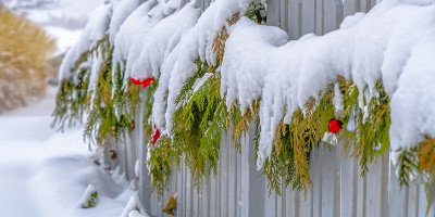装饰着节日花环的木栅栏被白雪覆盖