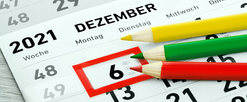 3铅笔，红色，绿色，黄色和德国日历2021年12月6日和工作日