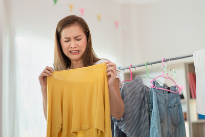 家庭主妇亚洲妇女是臭气熏天发霉的衣服