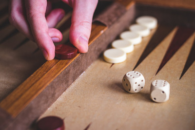 玩西洋双陆棋游戏。男人玩棋盘游戏。