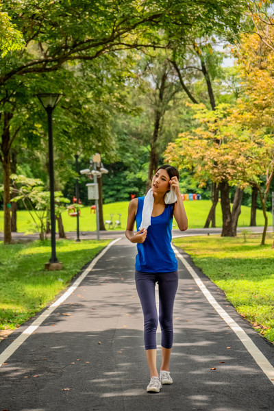 亚洲年轻女孩在公园慢跑后放松