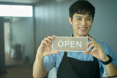 close up young business owner man holding open sig