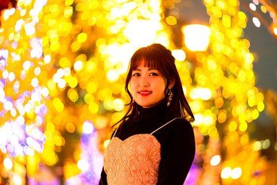 年轻女子站在灯光背景下