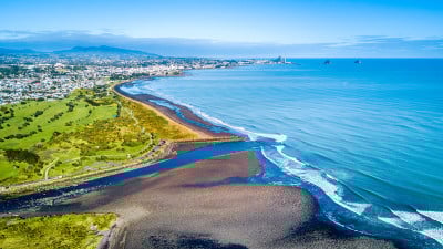 塔拉纳基海岸线的鸟瞰图，以一条小河和新普利茅斯为背景。新西兰的塔拉纳基地区