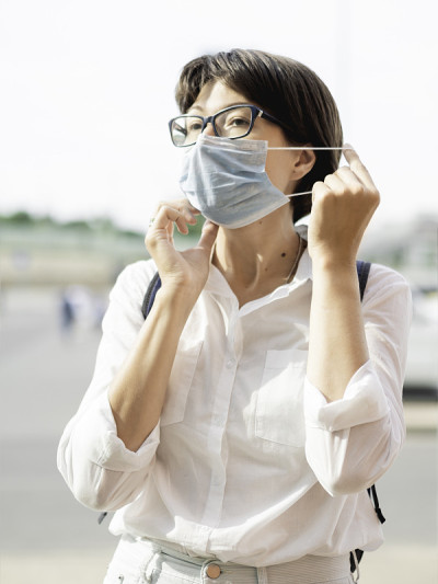 女性在进入商场前戴上医用防护口罩。新冠肺炎疫情防控措施。新常态