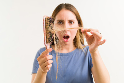 惊讶的女人看着她受损的头发