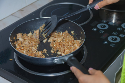 妇女们正在用磁炉做饭。