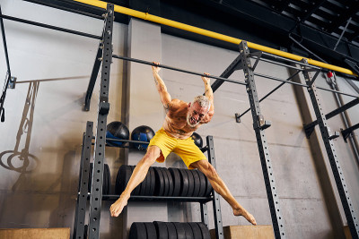 Mischievous sportsman working out on the push-up b