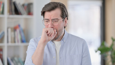 戴眼镜的病人在咳嗽的肖像