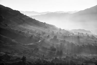 美丽的秋天风景日出在湖区，阳光透过雾流到langdale山谷