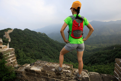成功的年轻女性徒步旅行者欣赏长城顶上的景色