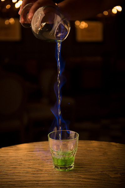 酒保倒着燃烧的苦艾酒