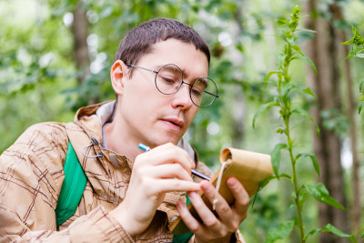 一张戴着眼镜的黑发生物学家的照片
